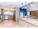 Open concept kitchen features a large island, stainless steel appliances, and backyard views at 9740 E Gold Dust Ave, Scottsdale, AZ 85258
