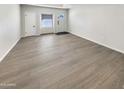 Spacious room with light gray wood flooring, a large window, and a neutral color scheme, ready for customization at 9814 N Balboa Dr, Sun City, AZ 85351