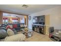 Comfortable living room featuring tile floors and an entertainment center with a large-screen TV at 1226 N Nevada Way, Mesa, AZ 85203