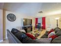 Well-lit living room with a large sectional sofa, tile flooring, and modern decor at 1226 N Nevada Way, Mesa, AZ 85203