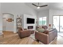 Spacious living room features a modern fireplace, vaulted ceiling, and comfortable leather seating at 16847 W Marconi Ave, Surprise, AZ 85388