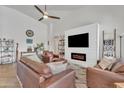 A bright living room featuring a fireplace, TV, and comfortable leather seating at 16847 W Marconi Ave, Surprise, AZ 85388
