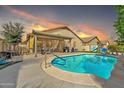 Inviting backyard pool and patio area, perfect for outdoor entertaining with sunset colors at 16847 W Marconi Ave, Surprise, AZ 85388