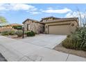 Attractive stone house with a two-car garage and lush desert landscaping at 18391 W Verdin Rd, Goodyear, AZ 85338