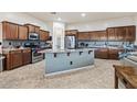 Open kitchen with a large center island, stainless steel appliances, and custom cabinetry at 18391 W Verdin Rd, Goodyear, AZ 85338