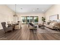 Open-concept living area with sliding glass doors, wood floors, dining area, and water views at 2043 E Clipper Ln, Gilbert, AZ 85234