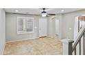 Living room with tile floors, neutral paint, ceiling fan, and large windows at 2568 E Boston St, Gilbert, AZ 85295