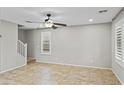 Living room with tile floors, neutral paint, ceiling fan, and large windows at 2568 E Boston St, Gilbert, AZ 85295
