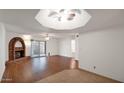 Spacious living room featuring a brick fireplace, wood floors, ceiling fan, and sliding glass door to the patio at 3345 E University E Dr # 71, Mesa, AZ 85213