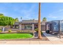 Charming single-story home featuring a well-manicured lawn, mature trees, and a private driveway with trailer at 4037 S Taylor Dr, Tempe, AZ 85282