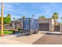 Charming single-story home featuring a well-manicured lawn, mature trees, and a private driveway with trailer at 4037 S Taylor Dr, Tempe, AZ 85282