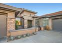 Inviting front entrance featuring stone accents, mature succulents, and a charming gate detail at 40930 N Lambert Trl, Phoenix, AZ 85086