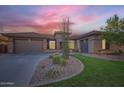 Charming single-story home featuring a lush green lawn, rock garden, and a spacious three-car garage at 40930 N Lambert Trl, Phoenix, AZ 85086