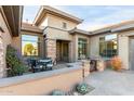 Charming front patio featuring a dining table, seating area, and beautifully landscaped desert plants and entryway at 40930 N Lambert Trl, Phoenix, AZ 85086