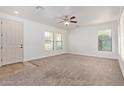 Spacious living room with neutral carpet, ceiling fan, and abundant natural light from multiple windows at 4428 E Wildhorse Dr, Gilbert, AZ 85297