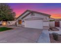 Home featuring a two-car garage, manicured lawn, and desert landscaping at 445 W Gary Ave, Gilbert, AZ 85233
