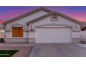 Home featuring a two-car garage, manicured lawn, and desert landscaping at 445 W Gary Ave, Gilbert, AZ 85233