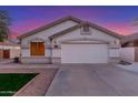 Home featuring a two-car garage, manicured lawn, and desert landscaping at 445 W Gary Ave, Gilbert, AZ 85233