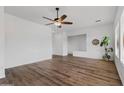 Spacious living room featuring hardwood floors, a ceiling fan, and natural light from multiple windows at 8117 E Sweet Bush Ln, Gold Canyon, AZ 85118