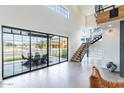 Bright living room features high ceilings, black framed windows, and stairs to the upper level at 8510 S 9Th Dr # 20, Phoenix, AZ 85041
