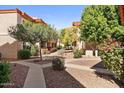 Serene courtyard with walking paths, mature trees, and manicured landscaping between apartment buildings at 10410 N Cave Creek Rd # 2034, Phoenix, AZ 85020