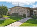 Home exterior featuring a green lawn, mature trees and a sidewalk leading to the entrance at 10533 W Granada Dr, Sun City, AZ 85373