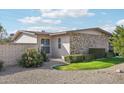 Beautiful landscaping with green lawn, decorative gravel and mature bushes surrounding the home at 10533 W Granada Dr, Sun City, AZ 85373