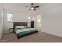 Bright main bedroom with a ceiling fan, carpet, and a view into the attached bathroom at 11744 S 173Rd Ln, Goodyear, AZ 85338