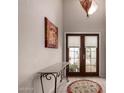 Elegant entryway with decorative lighting, console table, and double doors at 1202 E Winged Foot Rd, Phoenix, AZ 85022