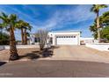 Charming front exterior of a home with a two-car garage and desert landscaping at 1202 E Winged Foot Rd, Phoenix, AZ 85022