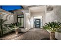 Close-up of the front entrance, showcasing a stylish door, decorative plants, and a paved walkway at 122 E Desert Wind Dr, Phoenix, AZ 85048