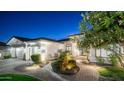 Inviting single-story home with a paved driveway, lush landscaping, and a cozy seating area at the entrance at 122 E Desert Wind Dr, Phoenix, AZ 85048