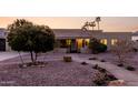 Home featuring desert landscaping with rock mulch, a mature shade tree, and a gated front porch at 12222 S Appaloosa Dr, Phoenix, AZ 85044