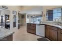 Well-lit kitchen boasts granite countertops, a breakfast bar and stainless steel appliances at 12323 W Fieldstone Dr, Sun City West, AZ 85375