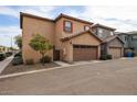 Attached two-car garage with decorative brown door, stucco exterior, and well-maintained landscaping at 1835 W Minton St, Phoenix, AZ 85041