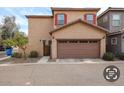 Attached two-car garage with decorative brown door, stucco exterior, and fresh landscaping at 1835 W Minton St, Phoenix, AZ 85041