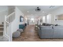 Open-concept living room with staircase, kitchen view, and a stylish blue media console at 1901 W 23Rd Ave, Apache Junction, AZ 85120