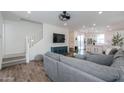 Inviting living room featuring a gray sofa, stairs, view into the kitchen, and a ceiling fan at 1901 W 23Rd Ave, Apache Junction, AZ 85120