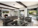 Open-concept living room with beamed ceilings, fireplace, and seamless indoor-outdoor flow to the backyard at 20299 N 102Nd Pl, Scottsdale, AZ 85255