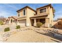 A detailed view of a two-story house highlighting the desert landscaping and two-car garage at 21397 N Goles Dr, Maricopa, AZ 85138