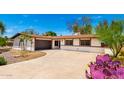 Single-story home showcasing a desert-style front yard with a winding driveway and attached garage at 2142 E Palmcroft Dr, Tempe, AZ 85282