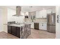 Modern kitchen features white cabinetry, stainless appliances, granite countertops and island with cooktop at 2142 E Palmcroft Dr, Tempe, AZ 85282