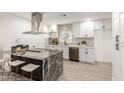 Bright kitchen features white cabinetry, stainless steel appliances, granite countertops, and an island with seating at 2142 E Palmcroft Dr, Tempe, AZ 85282