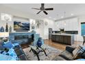 Inviting living room boasts a stone fireplace, TV, hardwood floors and a seamless transition to the modern kitchen at 22211 N 51St St, Phoenix, AZ 85054