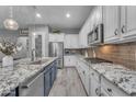 Modern kitchen featuring granite counters, stainless steel appliances, and white cabinets at 23004 E Desert Spoon Dr, Queen Creek, AZ 85142