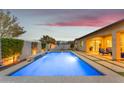 An in-ground pool is adjacent to the home and features a water feature, patio space, and a seating area at 23004 E Desert Spoon Dr, Queen Creek, AZ 85142