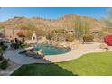 Beautiful backyard pool with mountain views, fireplace, and lounge seating at 27561 N 84Th Dr, Peoria, AZ 85383