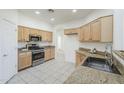 Functional kitchen featuring wood cabinetry, granite countertops, stainless steel appliances, and tile flooring at 2856 N 152Nd Ln, Goodyear, AZ 85395