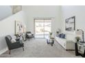 Inviting living room with high ceilings, neutral carpet, and access to the outdoor space through sliding glass doors at 2856 N 152Nd Ln, Goodyear, AZ 85395