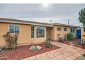 Exterior of a charming tan home with manicured landscaping and a brick walkway at 2929 N 55Th Pl, Phoenix, AZ 85018